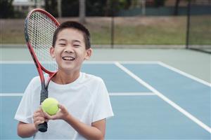 Young Boy with Tennis Racket and Ball